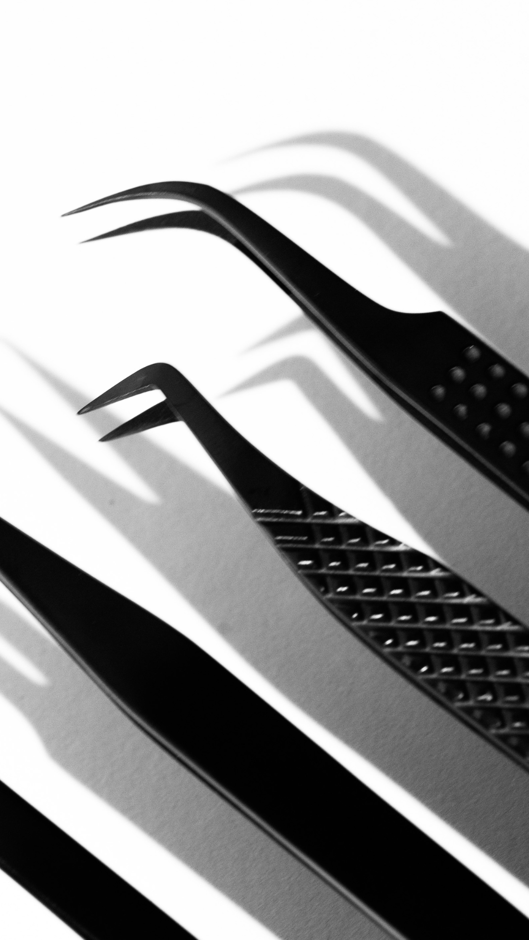 Close up of professional lash tweezers showing precision tips and textured grip for controlled lash application.