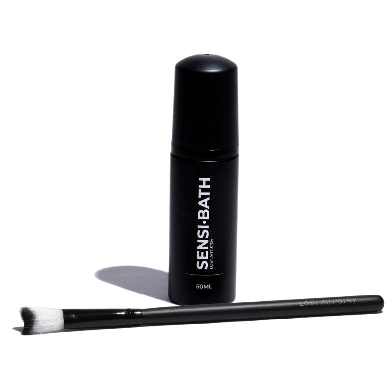 Black bottle labeled 'SENSI-BATH' with a brush on a white background
