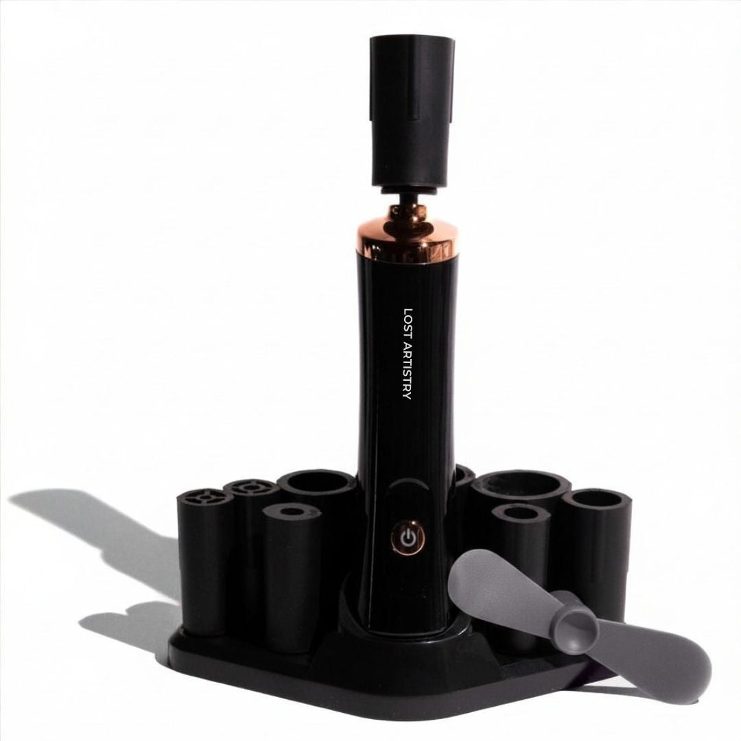 Black and rose gold lash glue shaking device with attachments on a white background