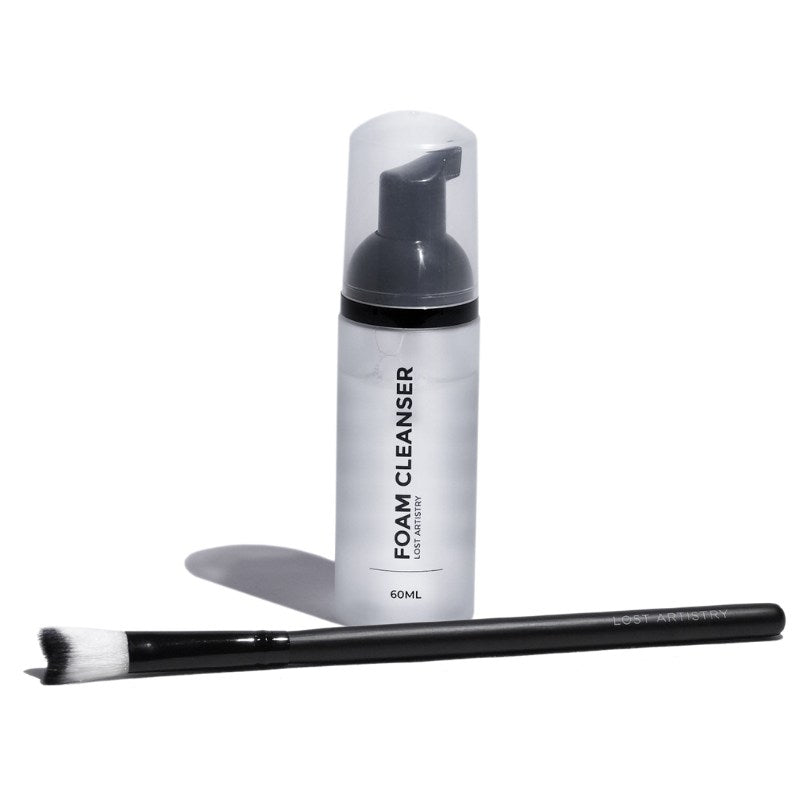 Foam cleanser bottle with a brush on a white background