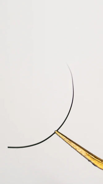 lash extension held by a lash tweezer