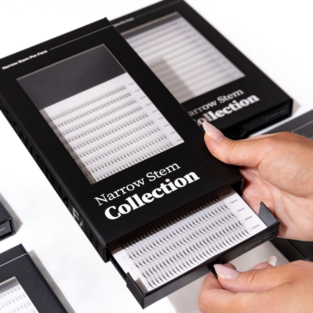 Eyelash extensions in a 'Narrow Stem Collection' box held by a hand on a white background